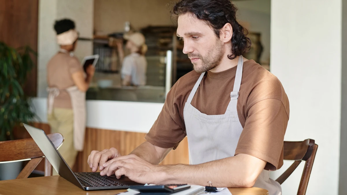 Business owner on computer in cafe setting